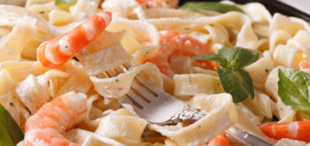 44756196 - fettuccini pasta in cream sauce with shrimp macro on a plate. horizontal